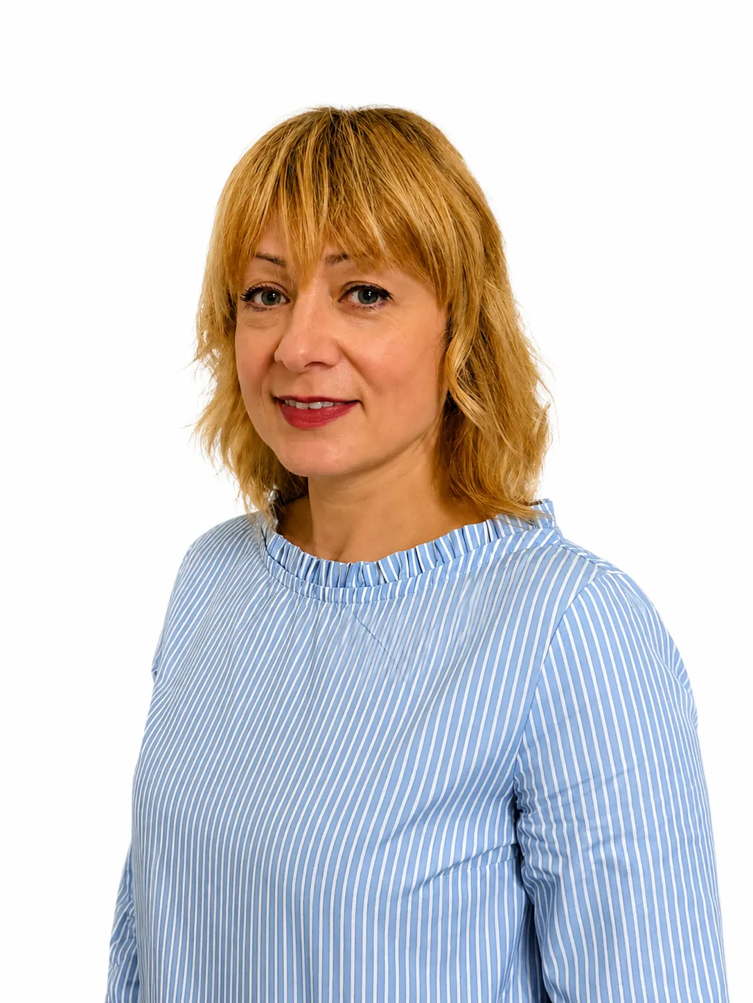 Woman with shoulder-length blonde hair wearing a blue and white striped blouse smiling slightly.