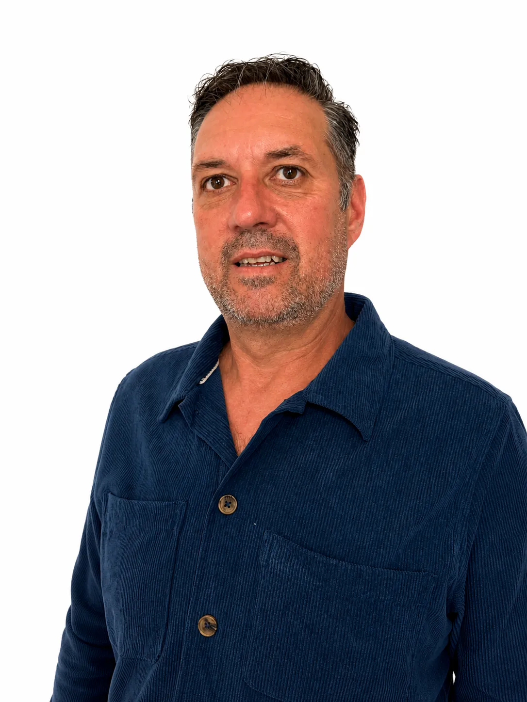 Middle-aged man with short hair and stubble wearing a blue corduroy shirt against white background.