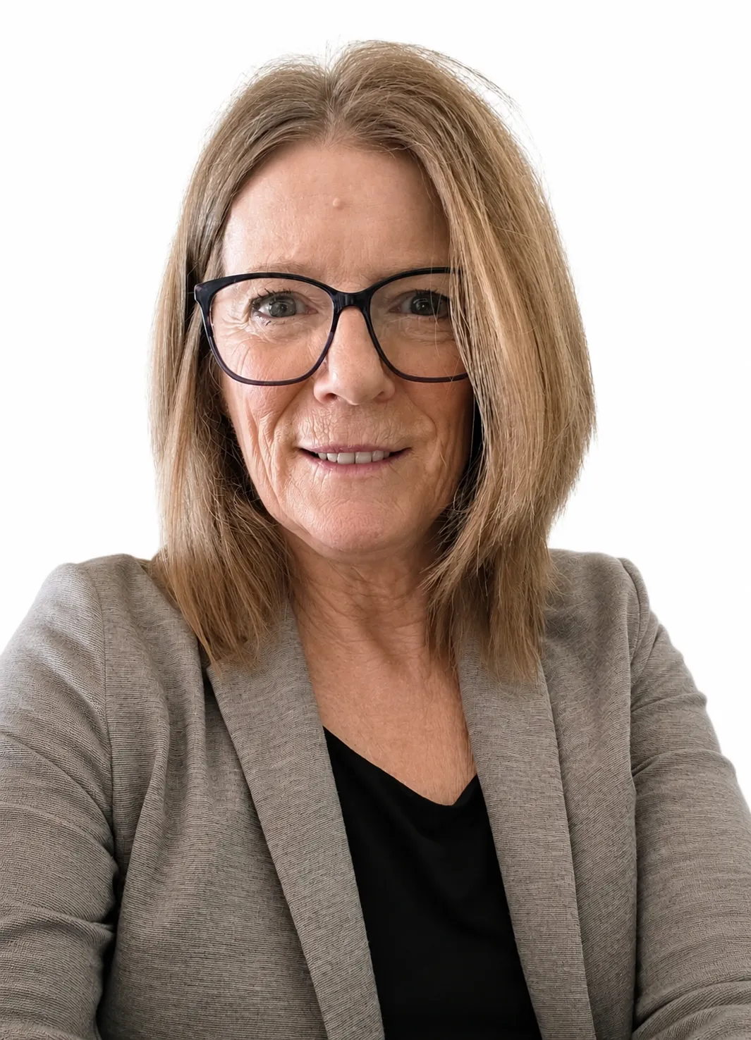 Middle-aged woman with glasses, shoulder-length hair, gray blazer, black top, smiling at the camera.