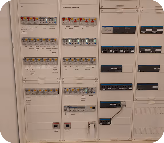 Elektrischer Sicherungskasten mit mehreren Reihen von Sicherungen, Schaltschaltern und Beschriftungen für verschiedene Stromkreise.