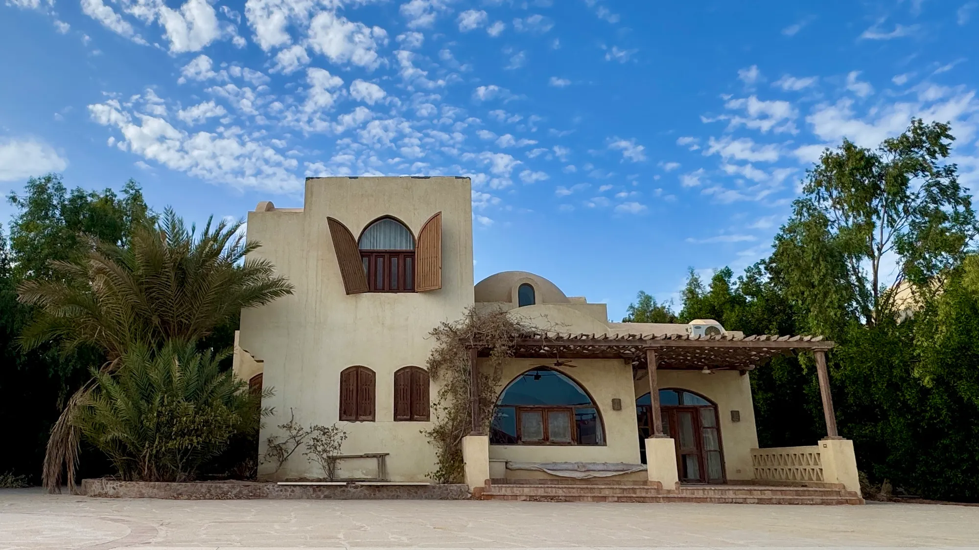 Traditional domed villa with wooden shutters among palms in New Nubia, El Gouna