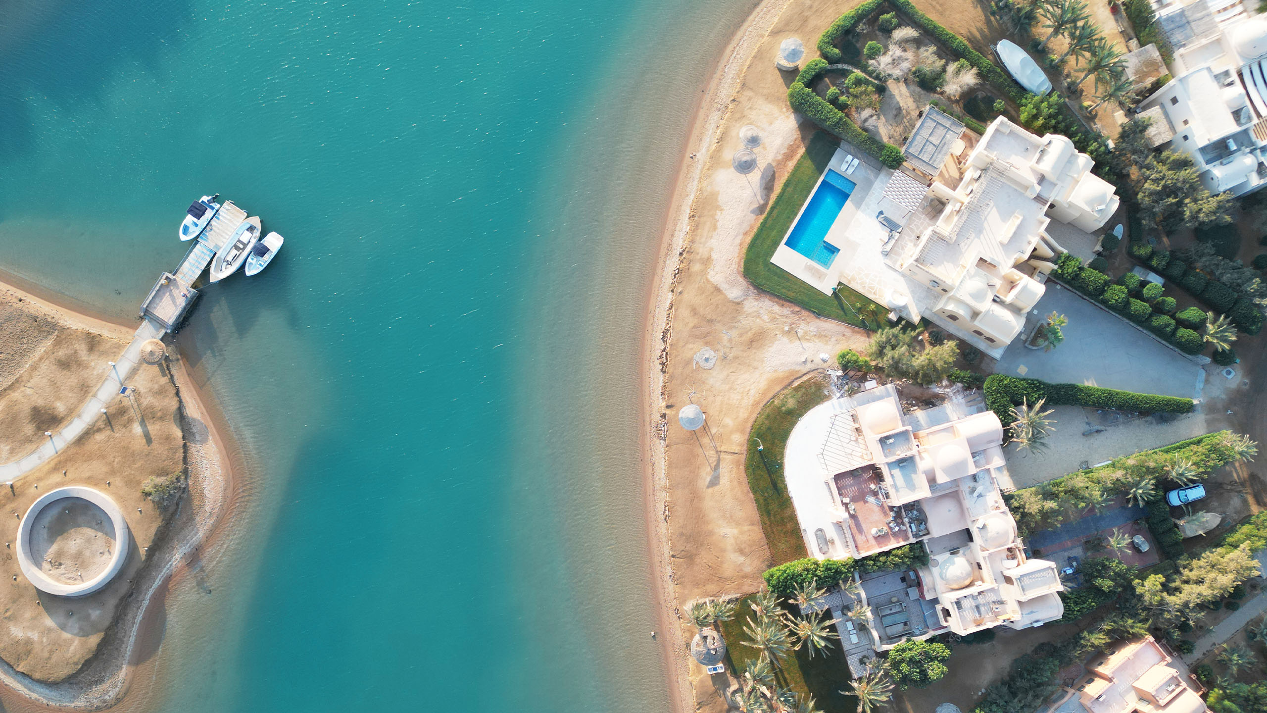 Aerial view of an El Gouna lagoon with a boat jetty opposite lagoon-front villas