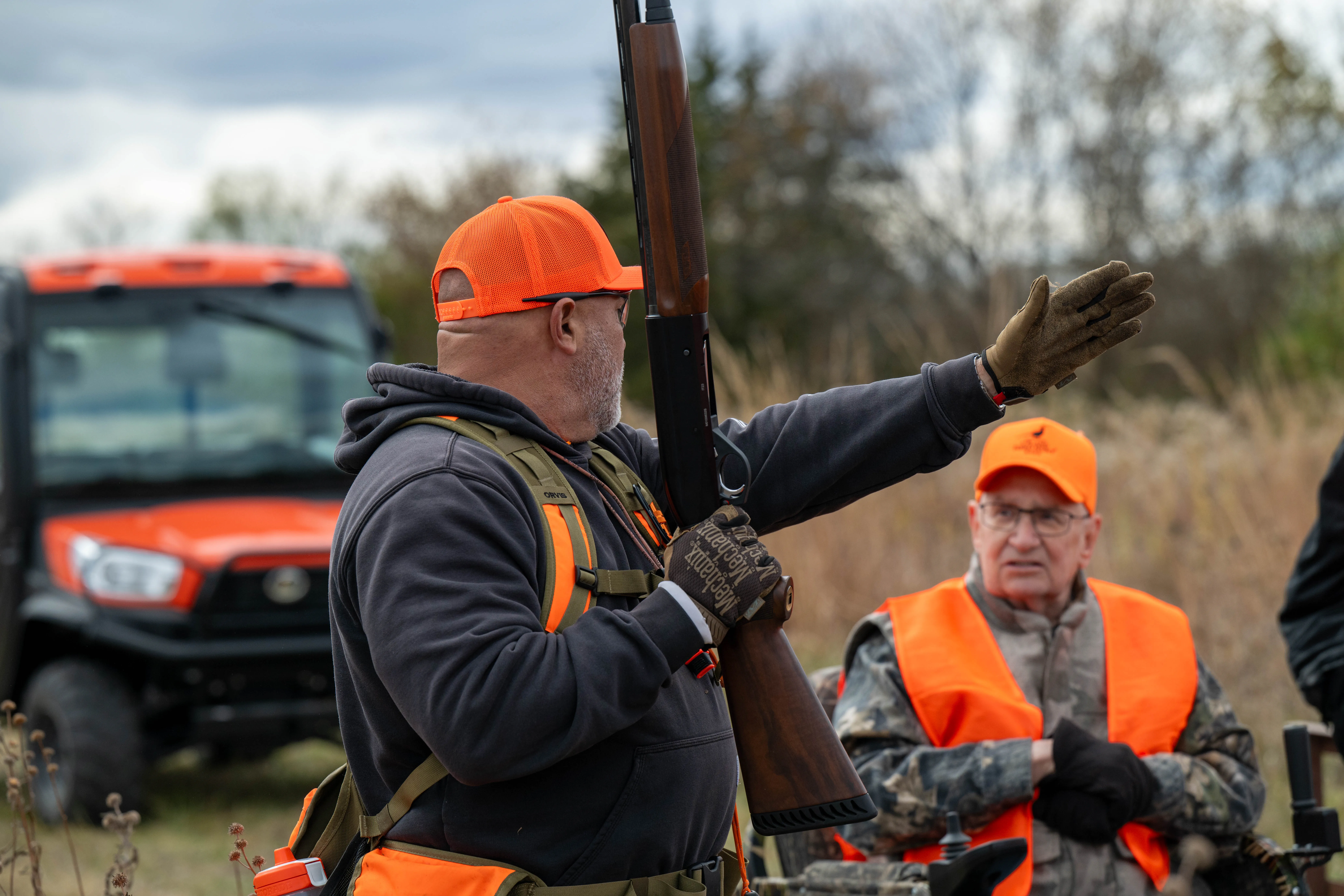 Two pheasant hunters walking through CRP with guide and his English Pointer