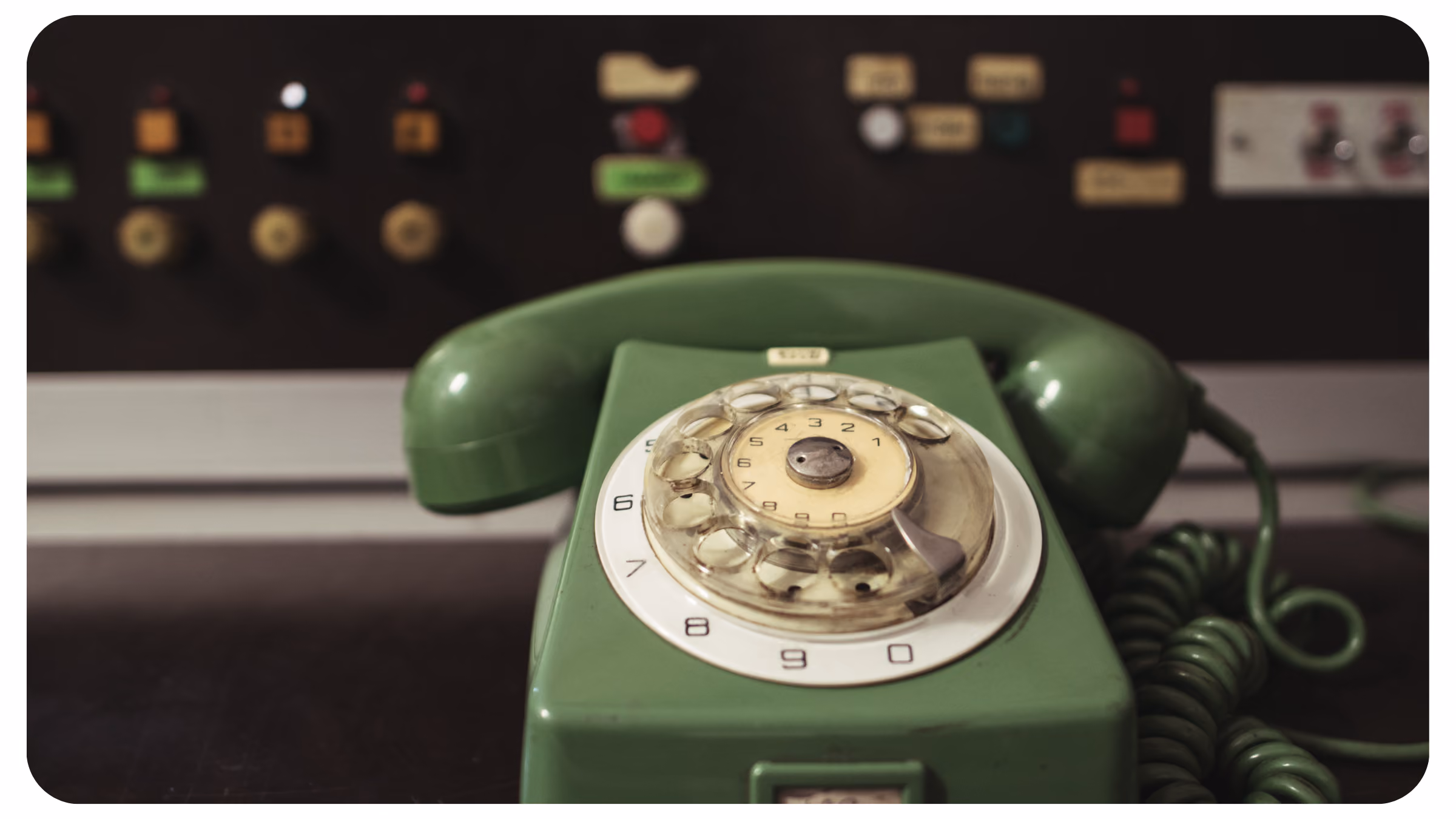 Altes grünes Telefon mit Wählscheibe.