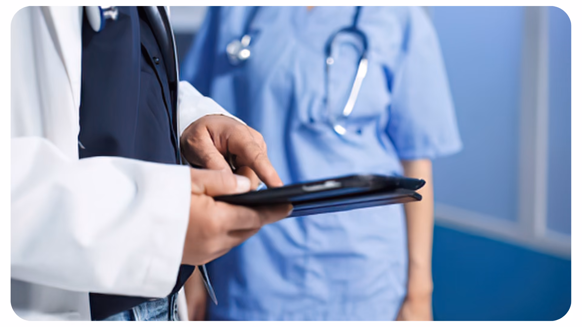 Zwei Personen in medizinischer Kleidung, eine hält ein Tablet, die andere trägt einen Stethoskop um den Hals