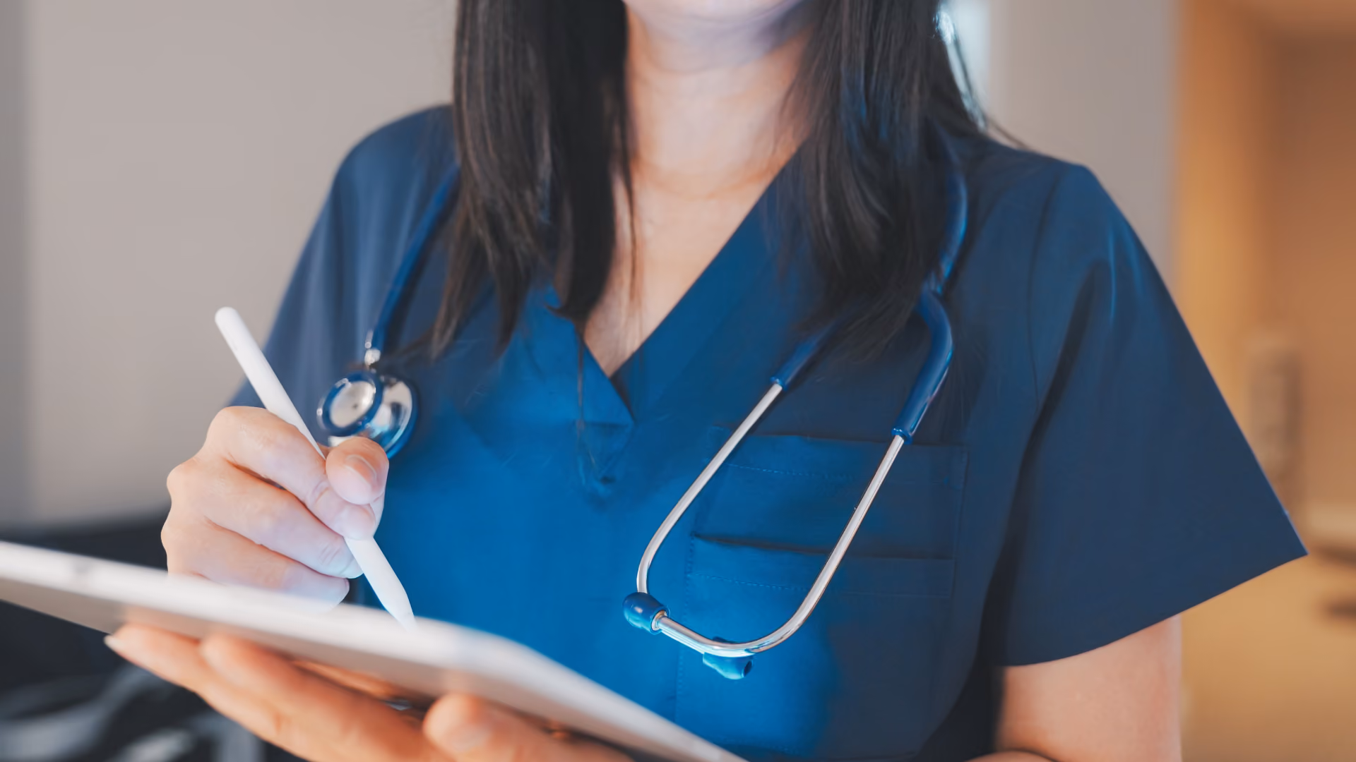 Eine Arzthelferin, die ein Tablet in der Hand hält.