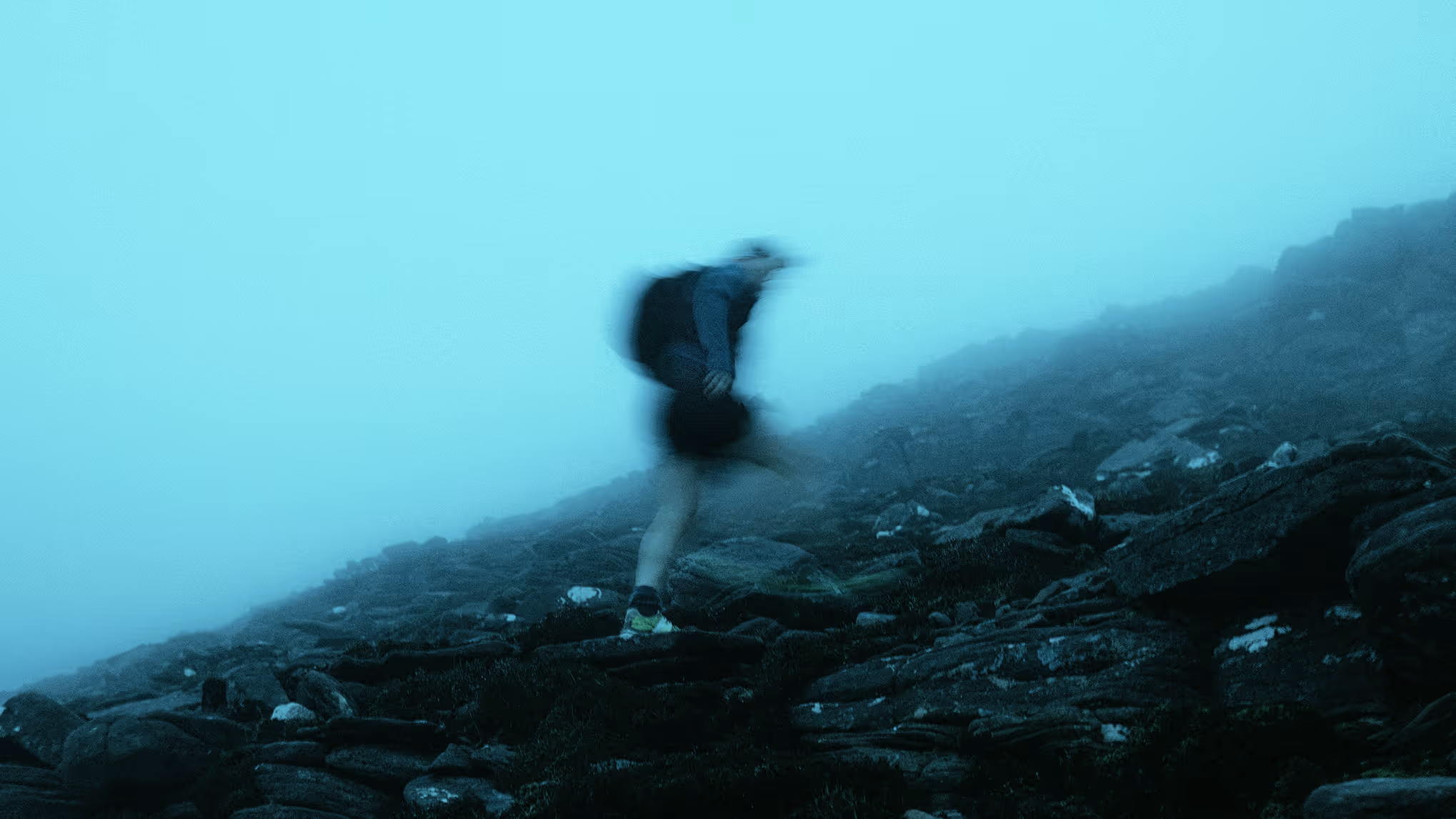 Hiker on a mountain trail with blue sky