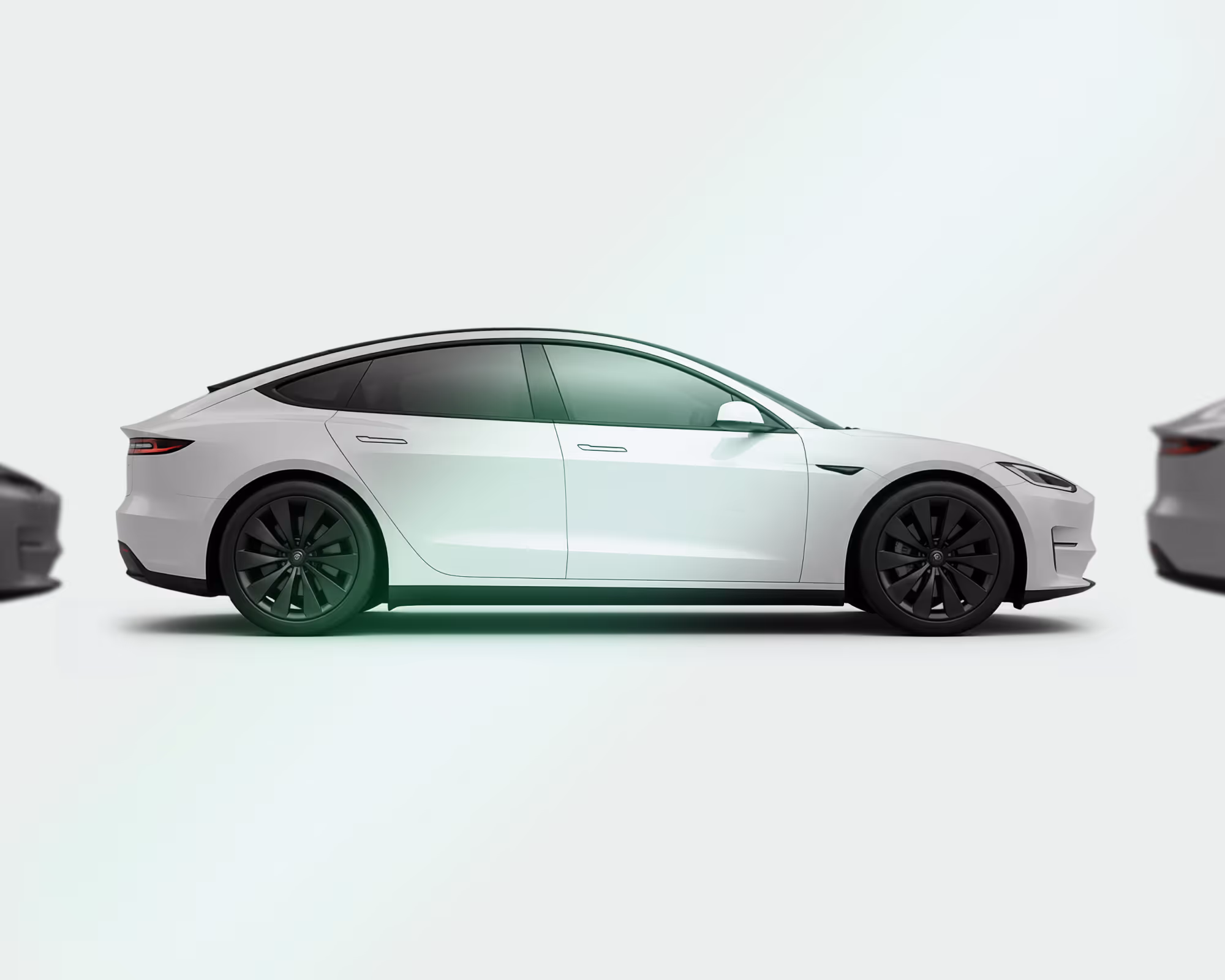 White electric car with black rims shown in profile on a light background with blurred vehicles.