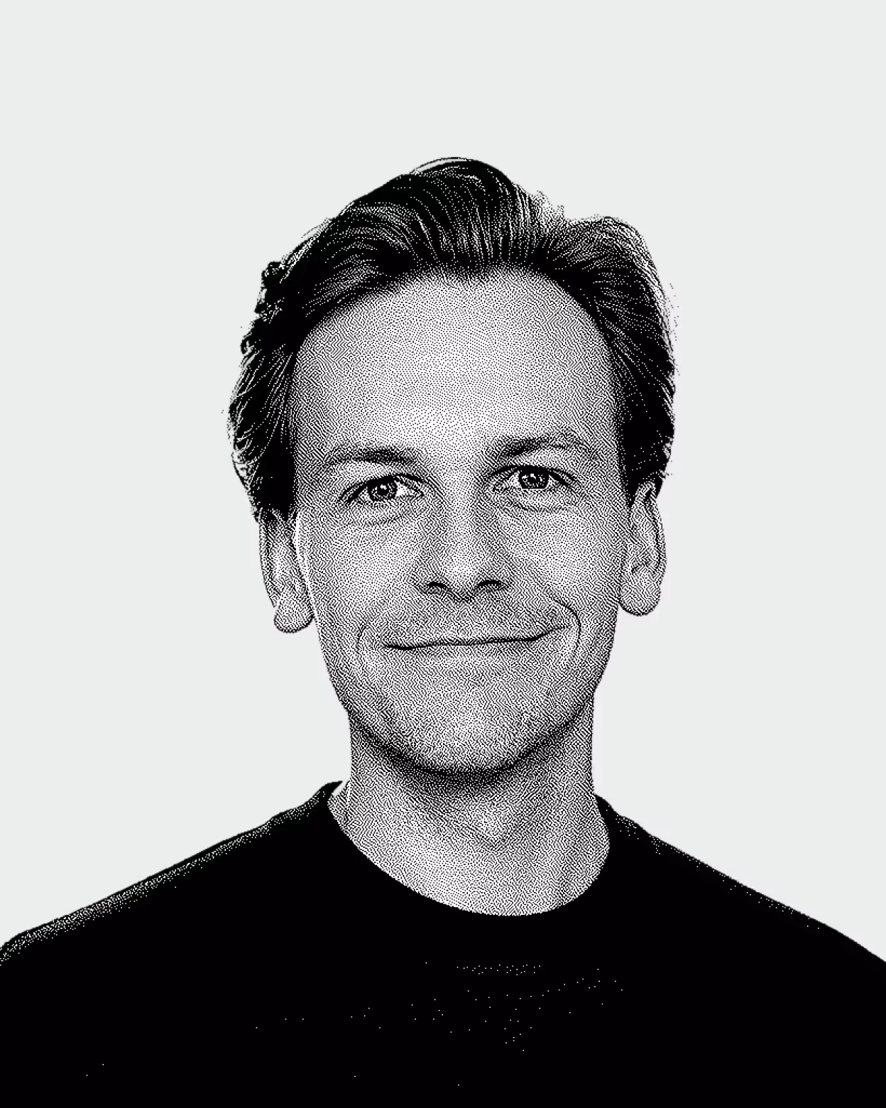 Simon Ludwig wearing a black shirt on a light background.