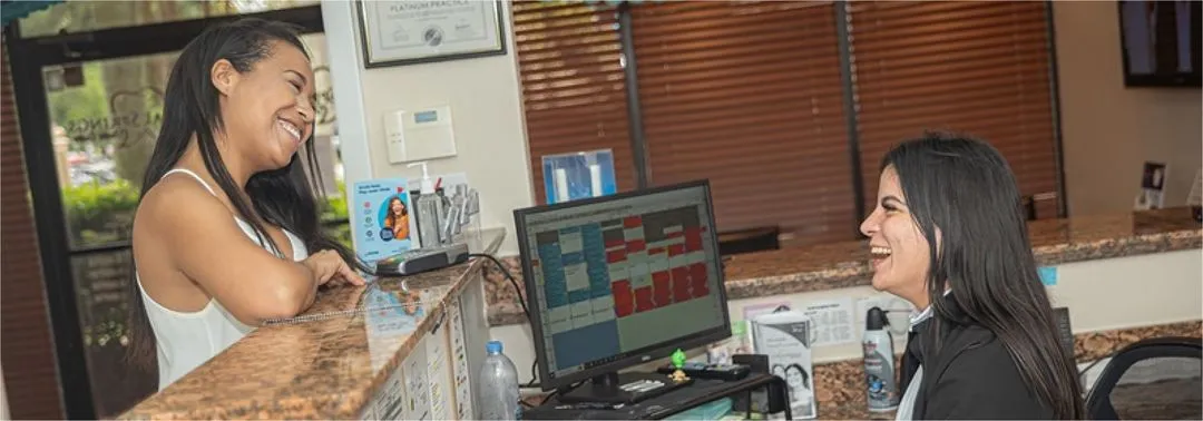 A woman standing at a counter talking to another woman.