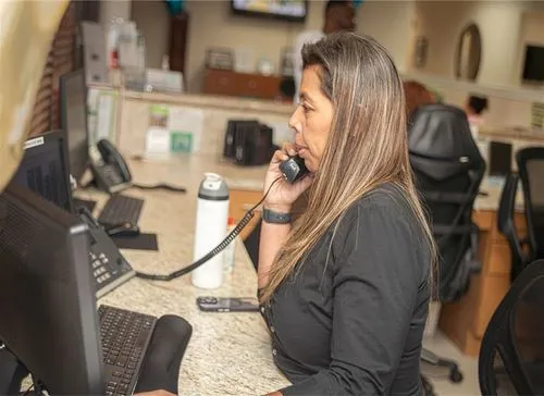 A woman sitting at a desk talking on a phone.