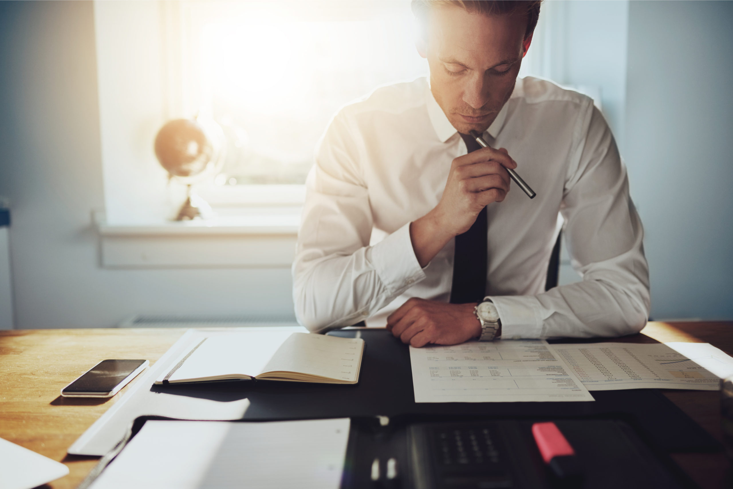 image illustrant un dirigeant dans son bureau, concentré, en train d'analyser un compte de résultat.