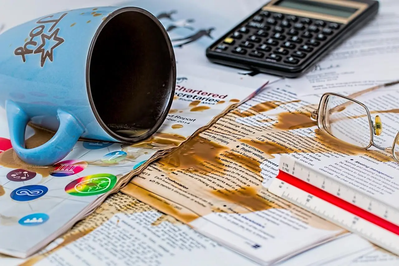 Un café qui est renversé sur des documents professionnels - recouvrement des créances clients