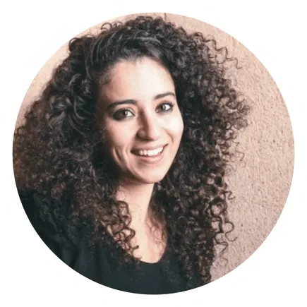 Portrait circulaire d'une femme souriante avec une veste noire et un fond flou.