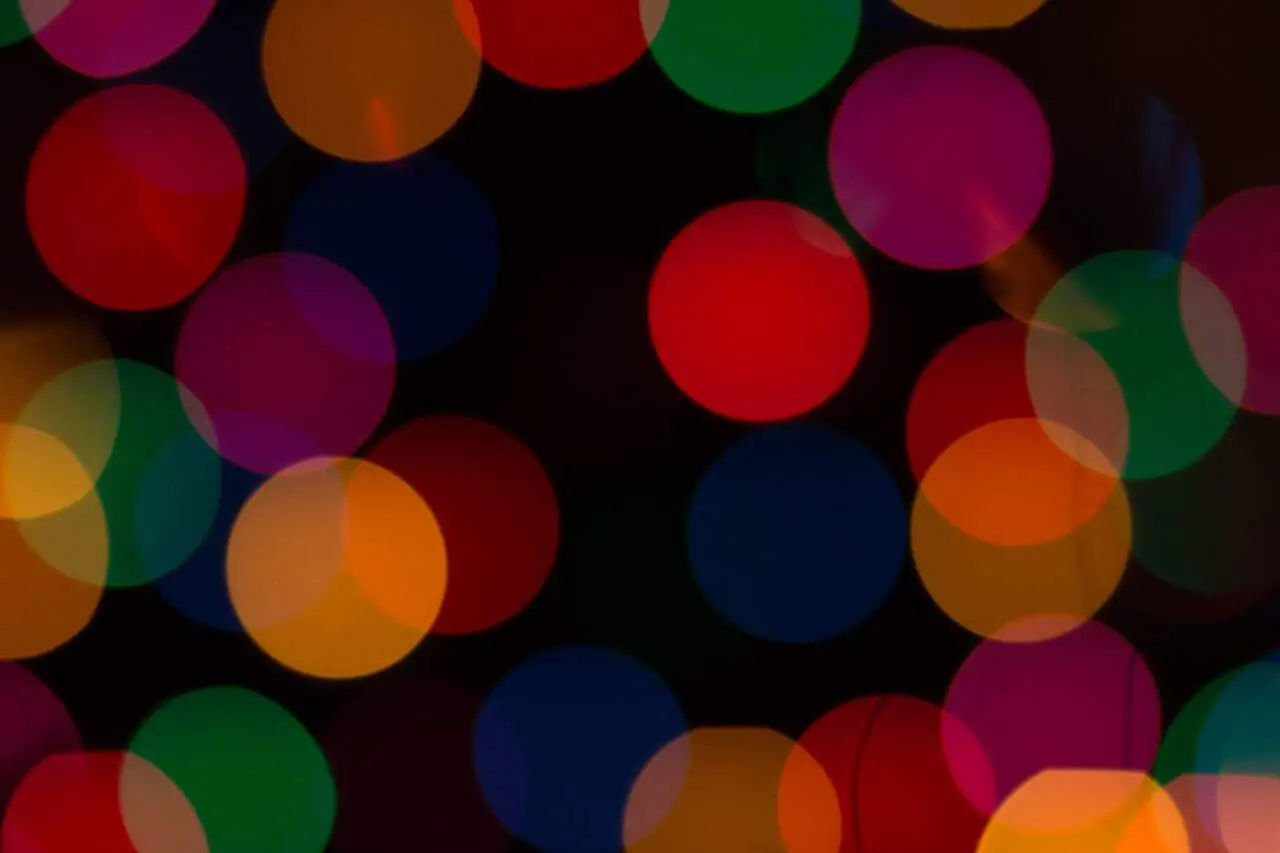 Overlapping circles of vivid colour—red, green, orange, and violet—float against a dark background, symbolising layered relationships, dynamic roles, and the interconnected nature of mandalic structure.