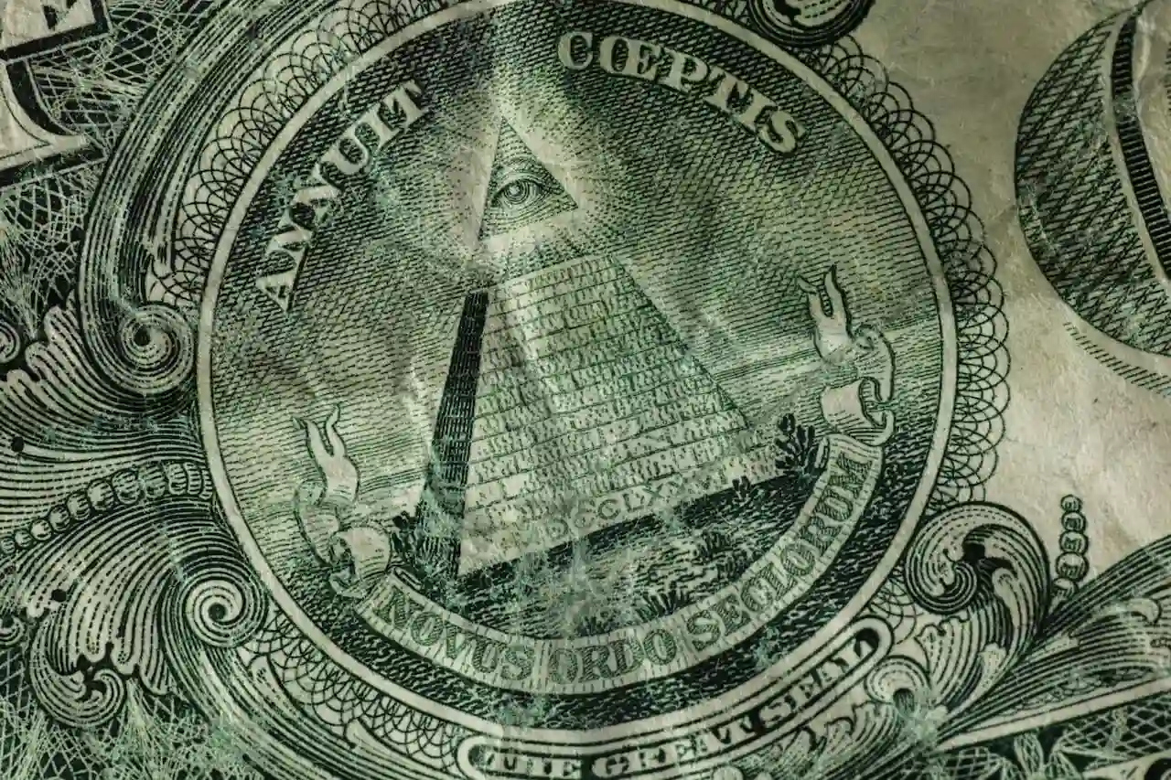 Close-up of the Great Seal of the United States as printed on the back of a one-dollar bill, showing the Eye of Providence above a pyramid with Latin phrases "Annuit Coeptis" and "Novus Ordo Seclorum."