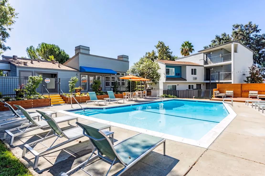 Exterior community amenity area featuring pool with lounge chairs
