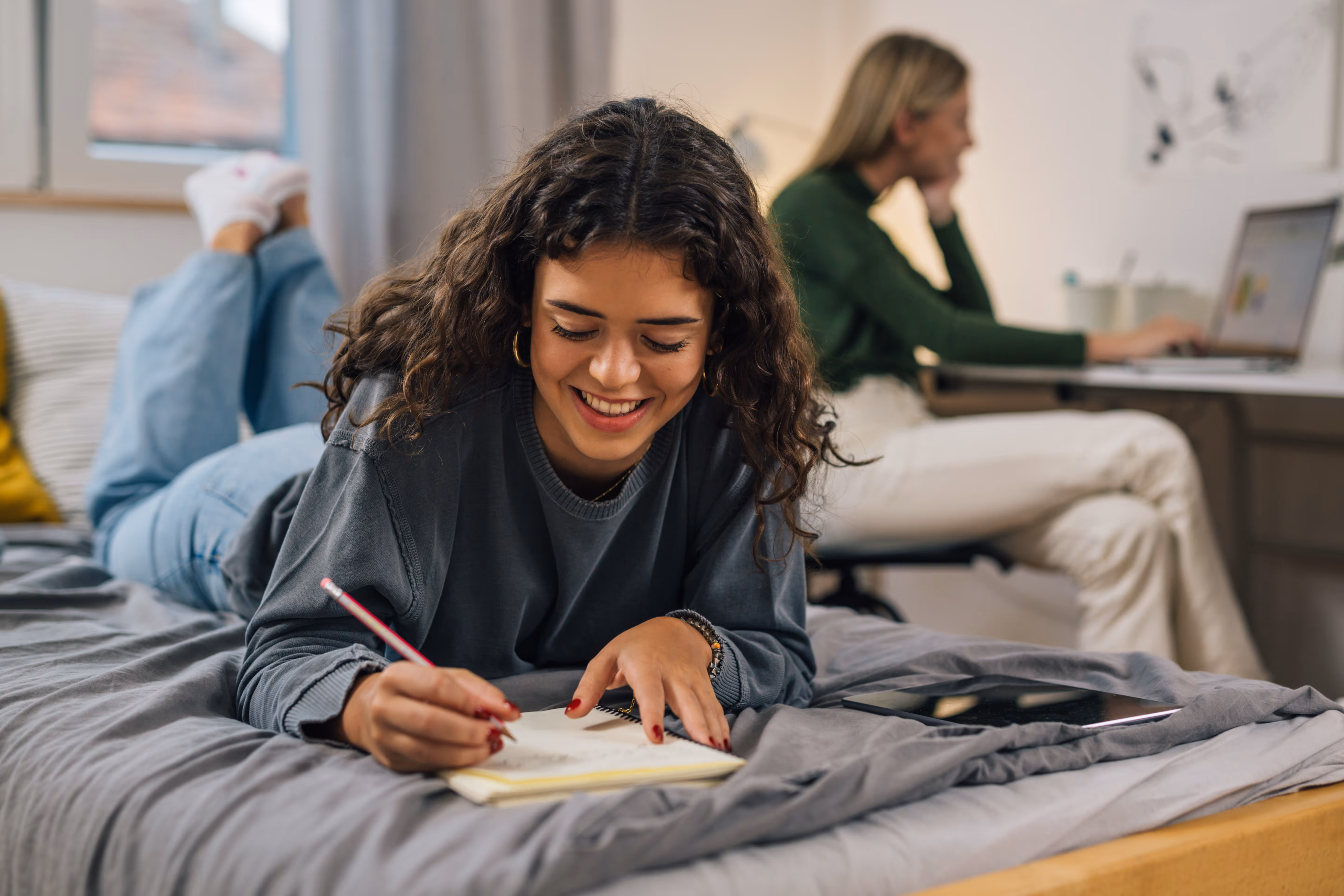 Girl writing in notebook on bed stock image