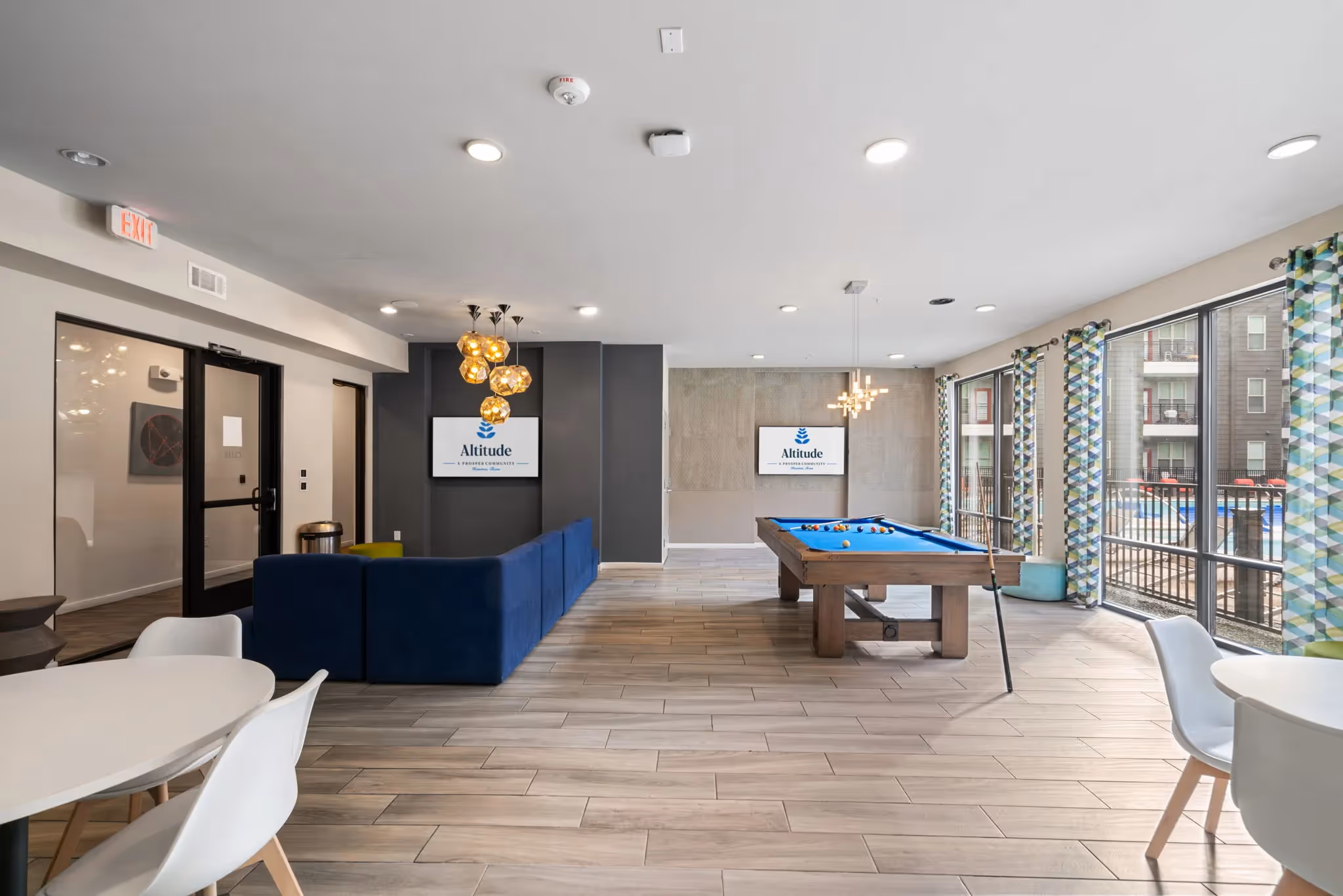 Vibrant resident lounge and game room with a billiards table and modern furniture, offering a social space at Altitude in Houston, TX.