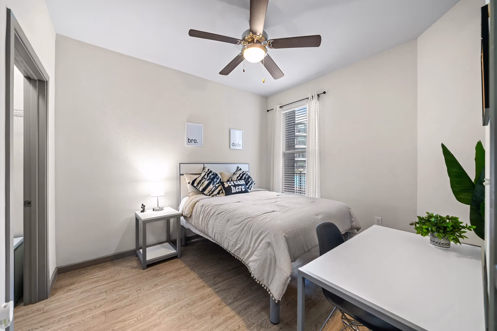 Bedroom with a modern bed, ceiling fan, and a desk, perfect for a student or professional at Altitude in Houston, TX.