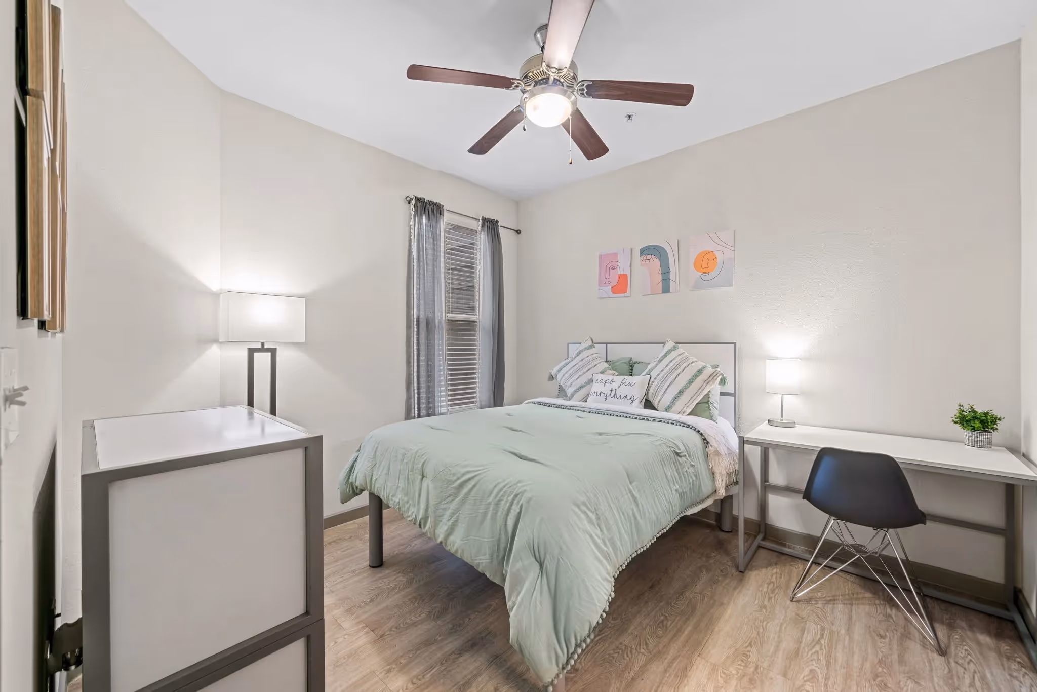 Bright bedroom with a modern bed, a desk for studying, and light green bedding in an apartment at Altitude in Houston, TX.
