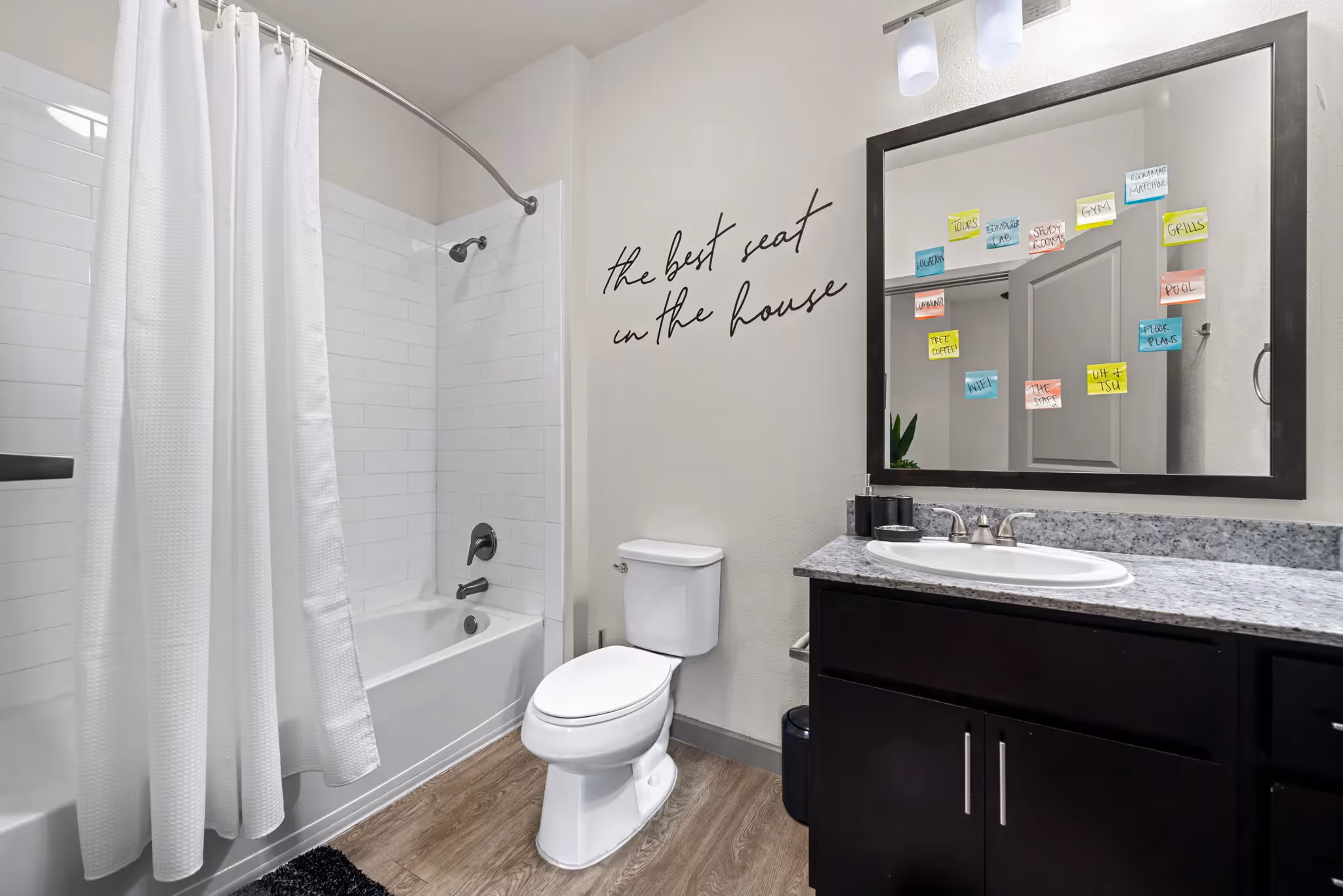 Stylish bathroom with a vanity, toilet, and shower/tub combination featuring subway tile, showcasing apartment finishes at Altitude in Houston, TX.
