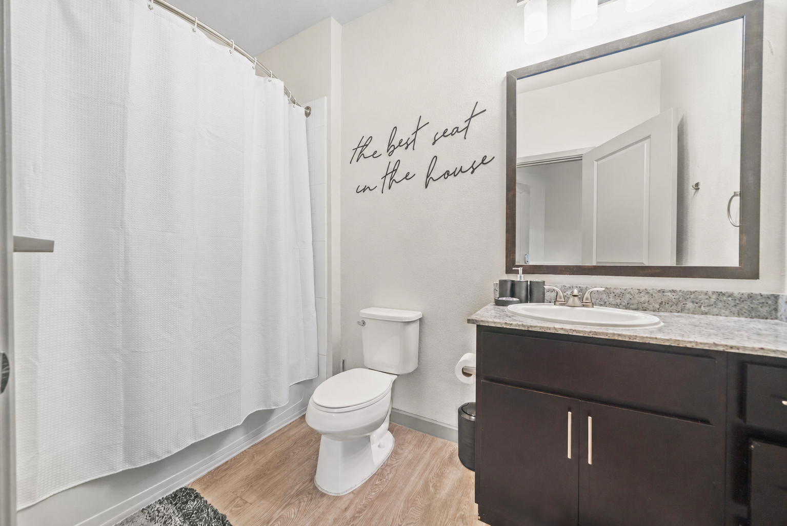 Stylish bathroom with a vanity, toilet, and shower/tub combination featuring subway tile, showcasing apartment finishes at Altitude in Houston, TX.