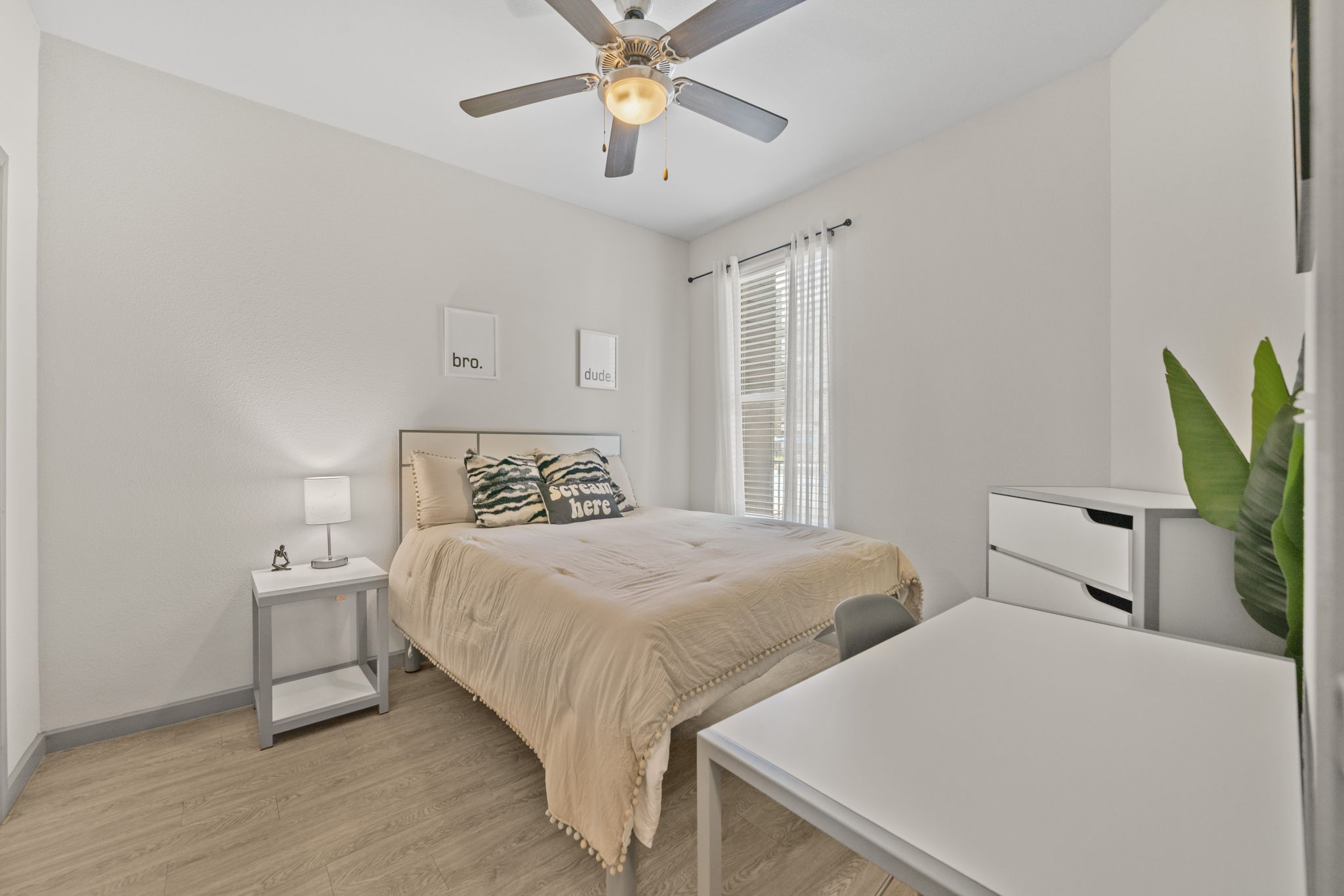Bedroom with a modern bed, ceiling fan, and a desk, perfect for a student or professional at Altitude in Houston, TX.