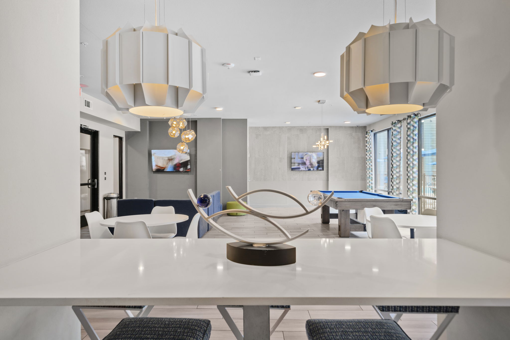 Vibrant resident lounge with a billiards table, comfortable seating, and large windows, perfect for socializing at Altitude in Houston, TX.