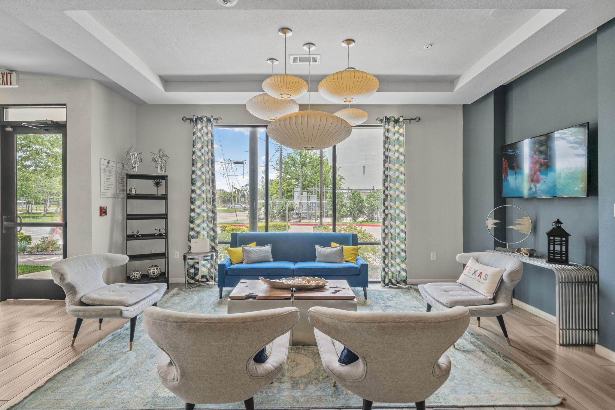 Modern resident lounge with a long bar counter, stylish pendant lights, and pool views, offering a chic social space at Altitude in Houston, TX.