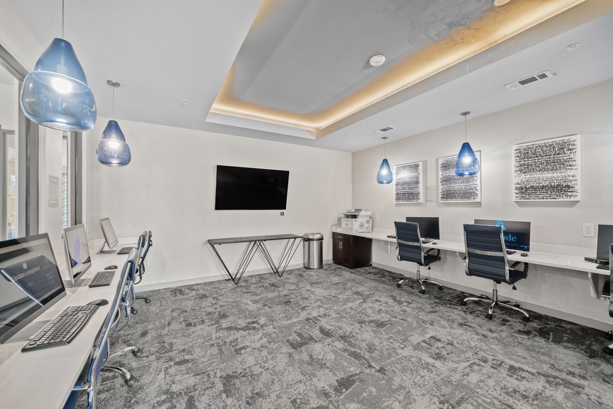 Community study lounge and business center with multiple computers, desks, and a printer, providing a productive environment at Altitude in Houston, TX.