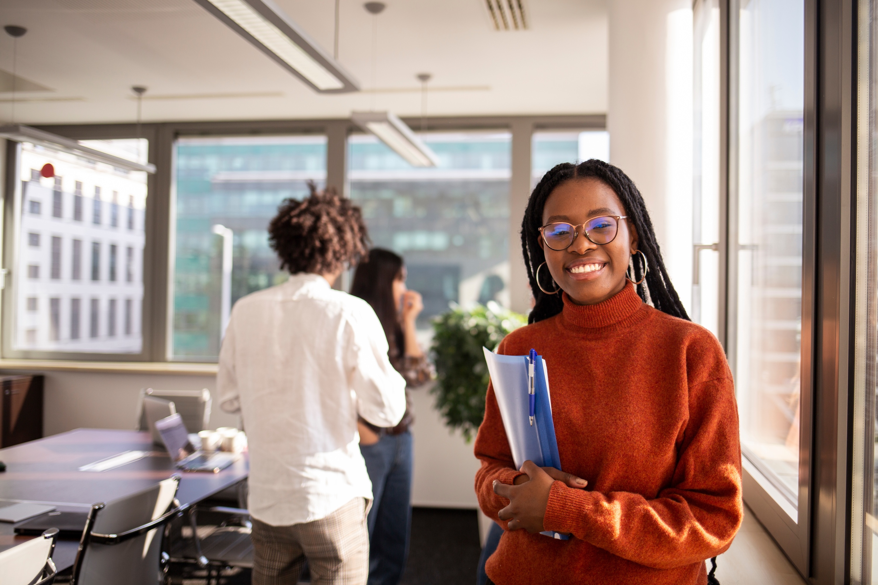 A smiling resident holding folders inside a community workspace near Altitude Apartments in Houston, TX.