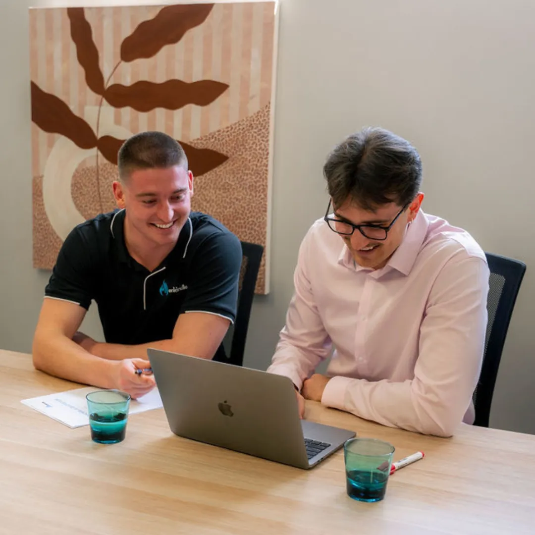 Enkindle Group founders going over marketing results on a laptop