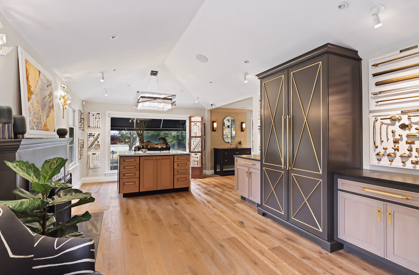 Modern showroom with black and gold cabinetry, wooden floor, and furniture hardware displays.