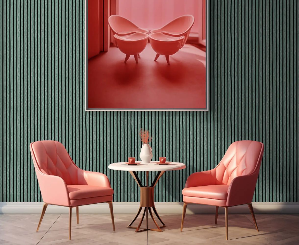 Two pink cushioned chairs with wooden legs and a small round table with cups and vase on green textured wall.