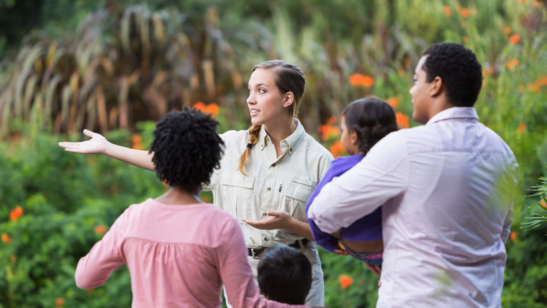 Tour guide facing the camera with a group behind them
