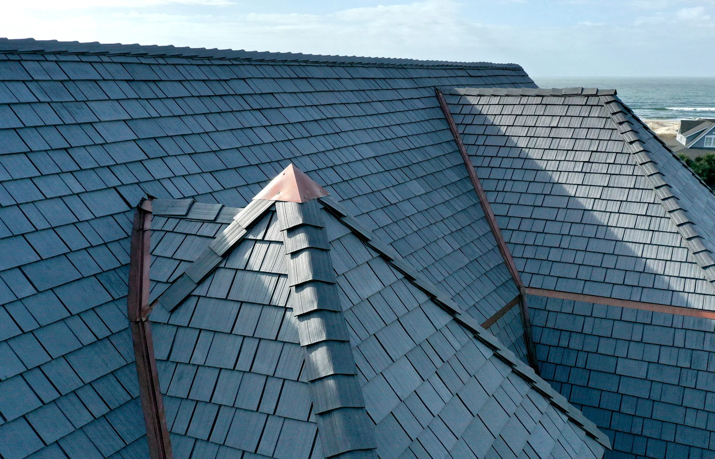 Blue-grey Enviroshake synthetic cedar shake roof with copper valleys on an oceanfront home