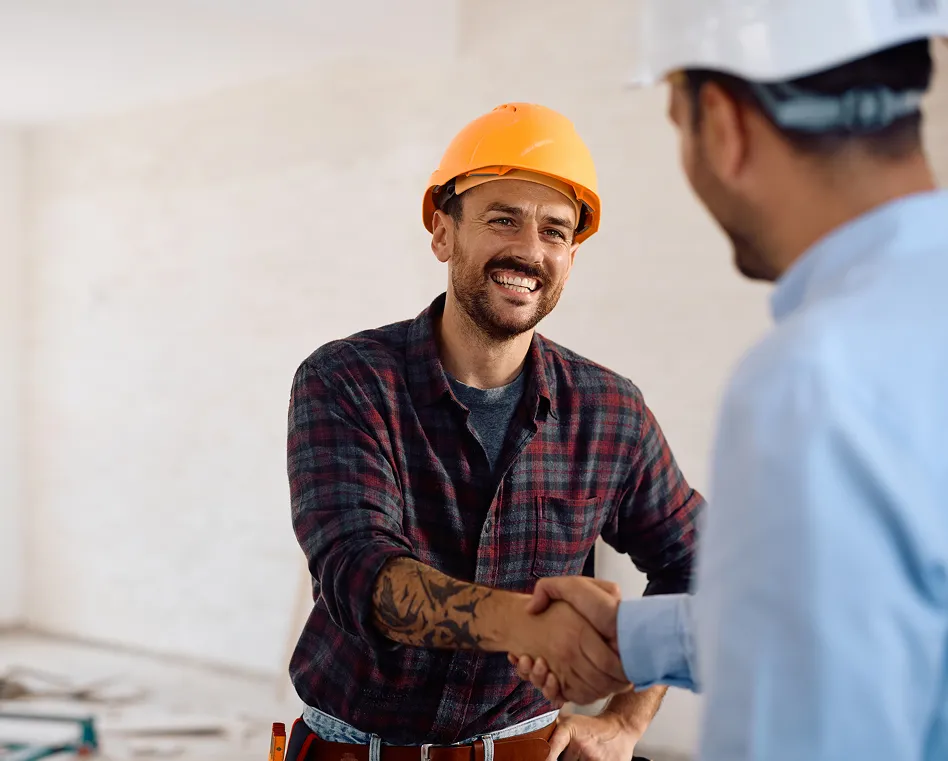 Roofing contractor shaking hands with a homeowner on a job site