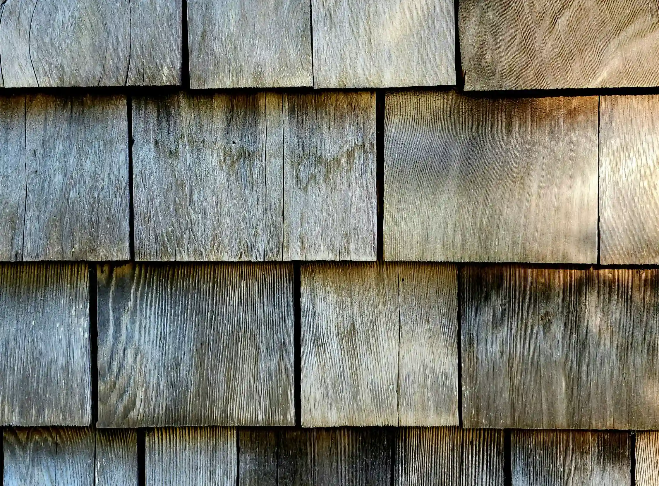 A weathered up-close swatch of natural cedar shingles