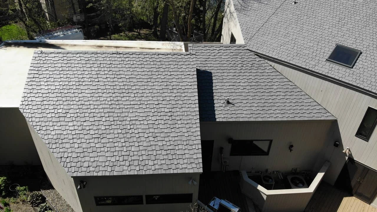 Aged Cedar Enviroshake composite roofing on a contemporary home surrounded by mature trees.