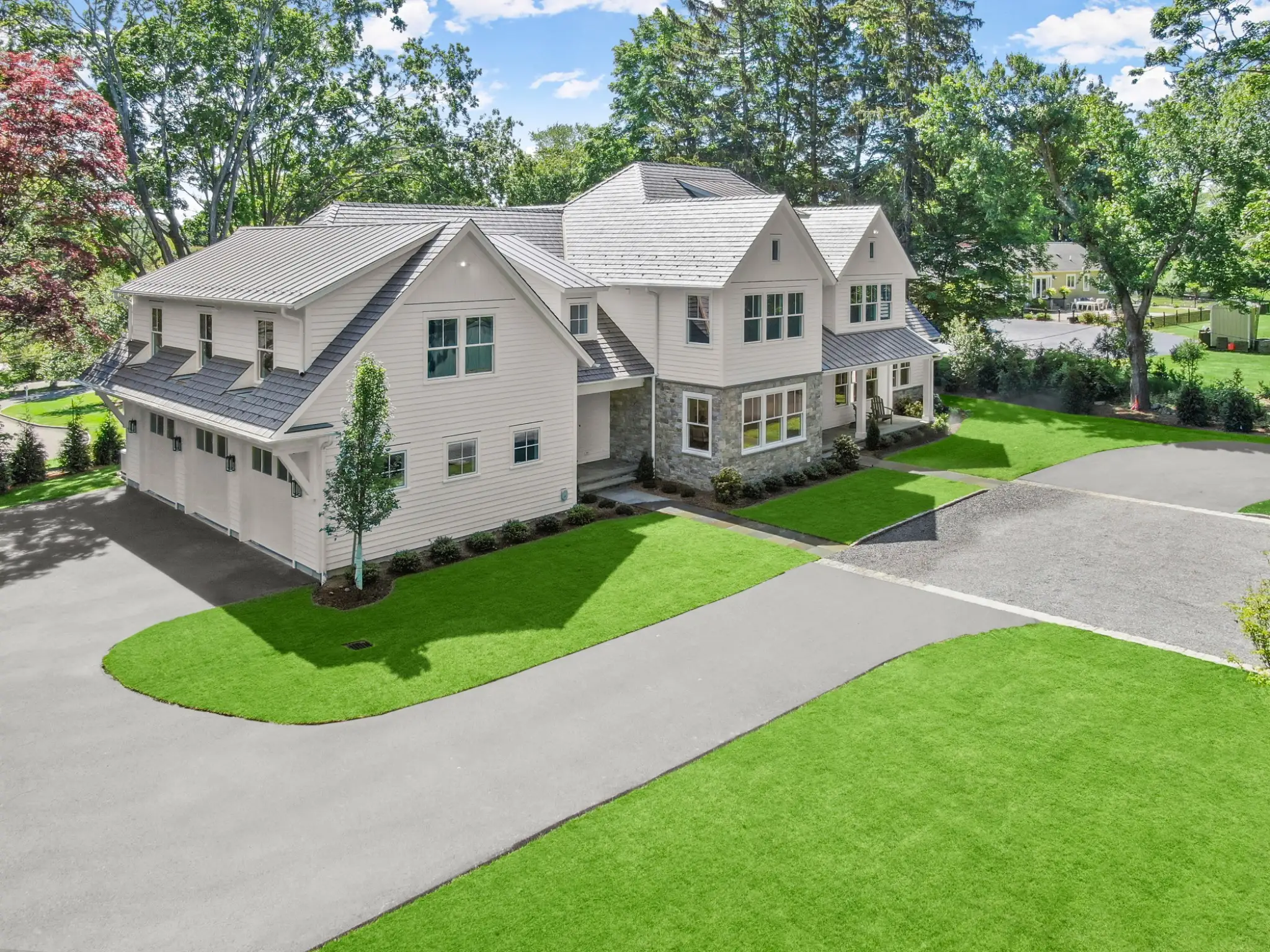 Enviroshake composite cedar shake roofing on a large luxury home with white siding, stone accents and multiple gables.