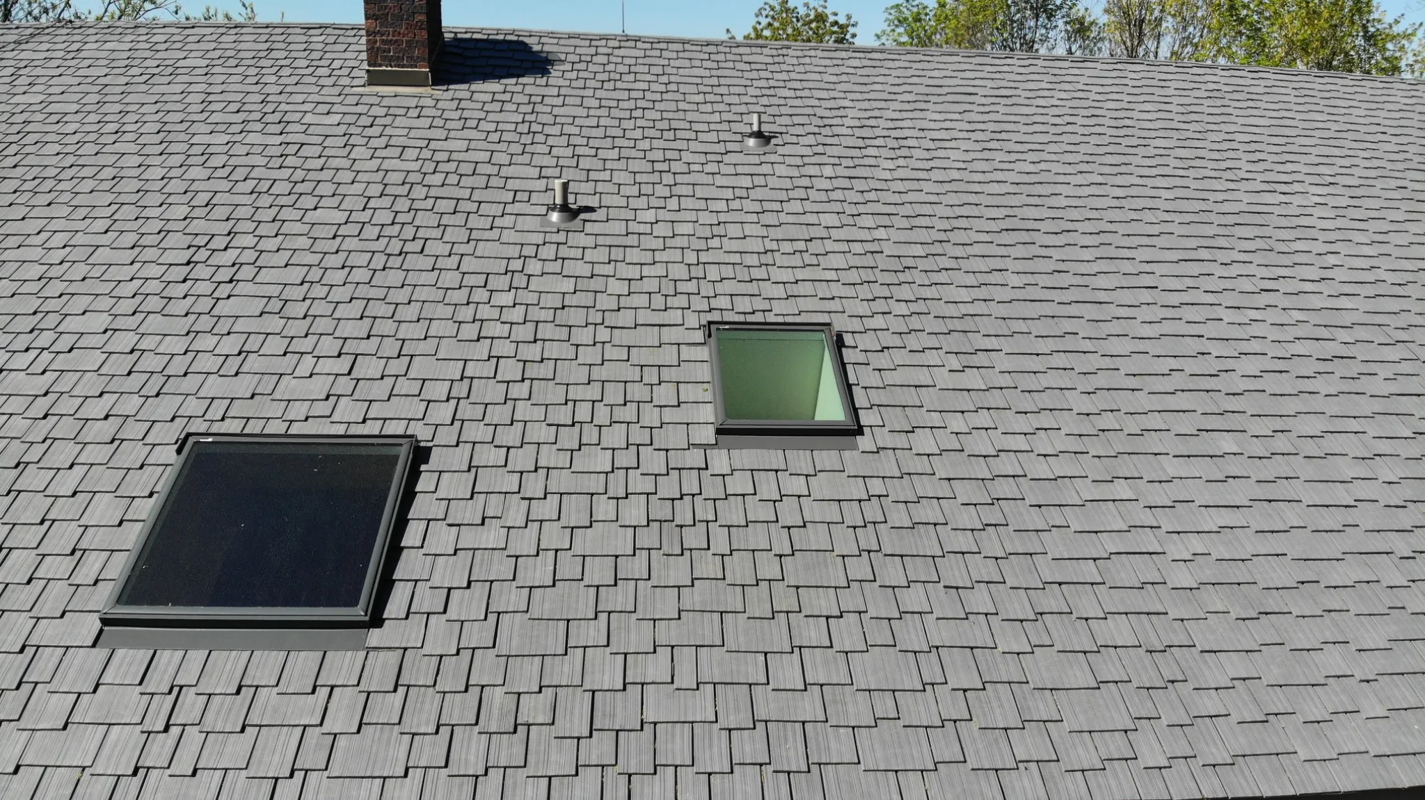 Enviroshake composite cedar shake roofing with a staggered installation pattern and skylights.