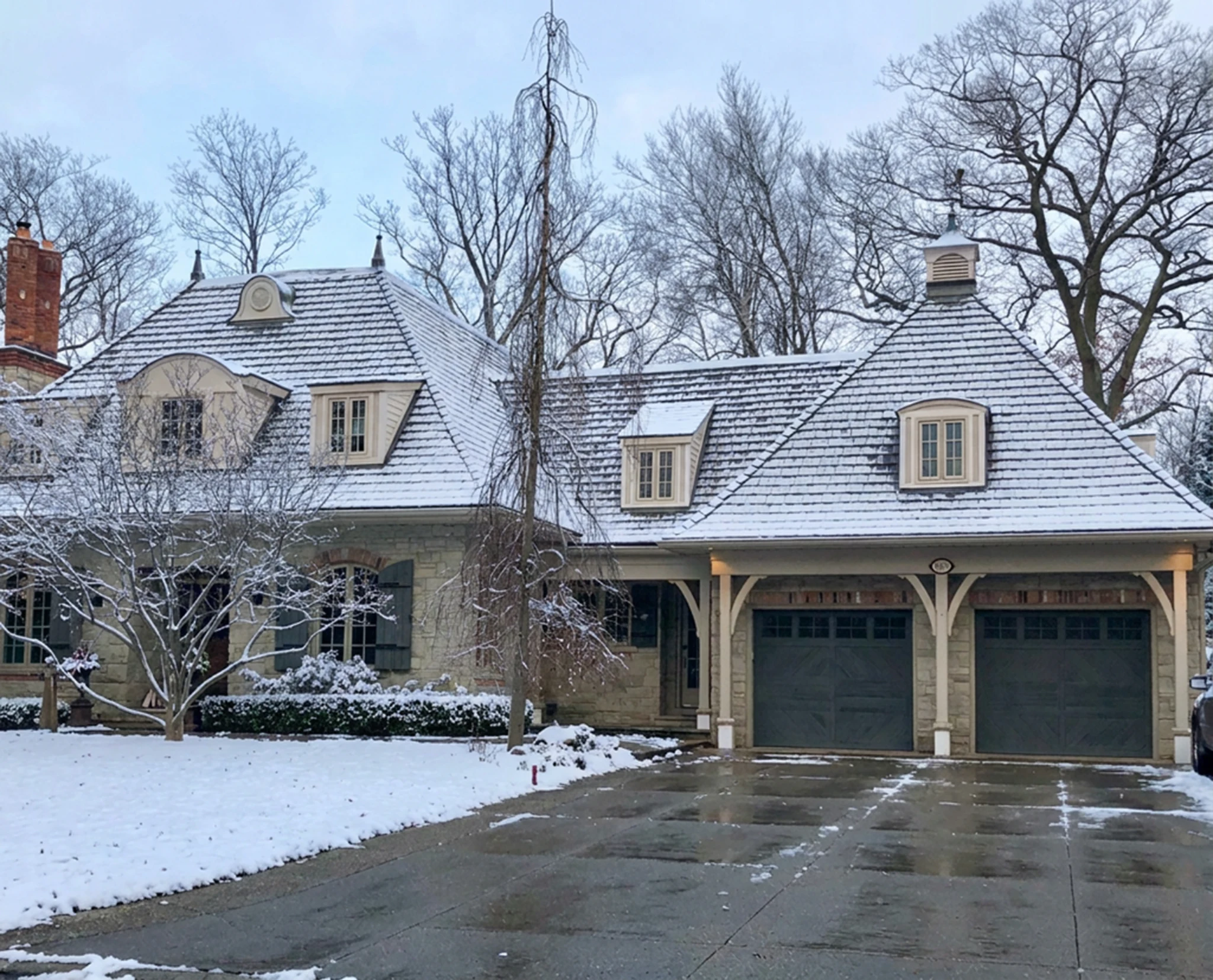 Enviroshake composite cedar shake roofing on a traditional stone home covered in fresh snow.
