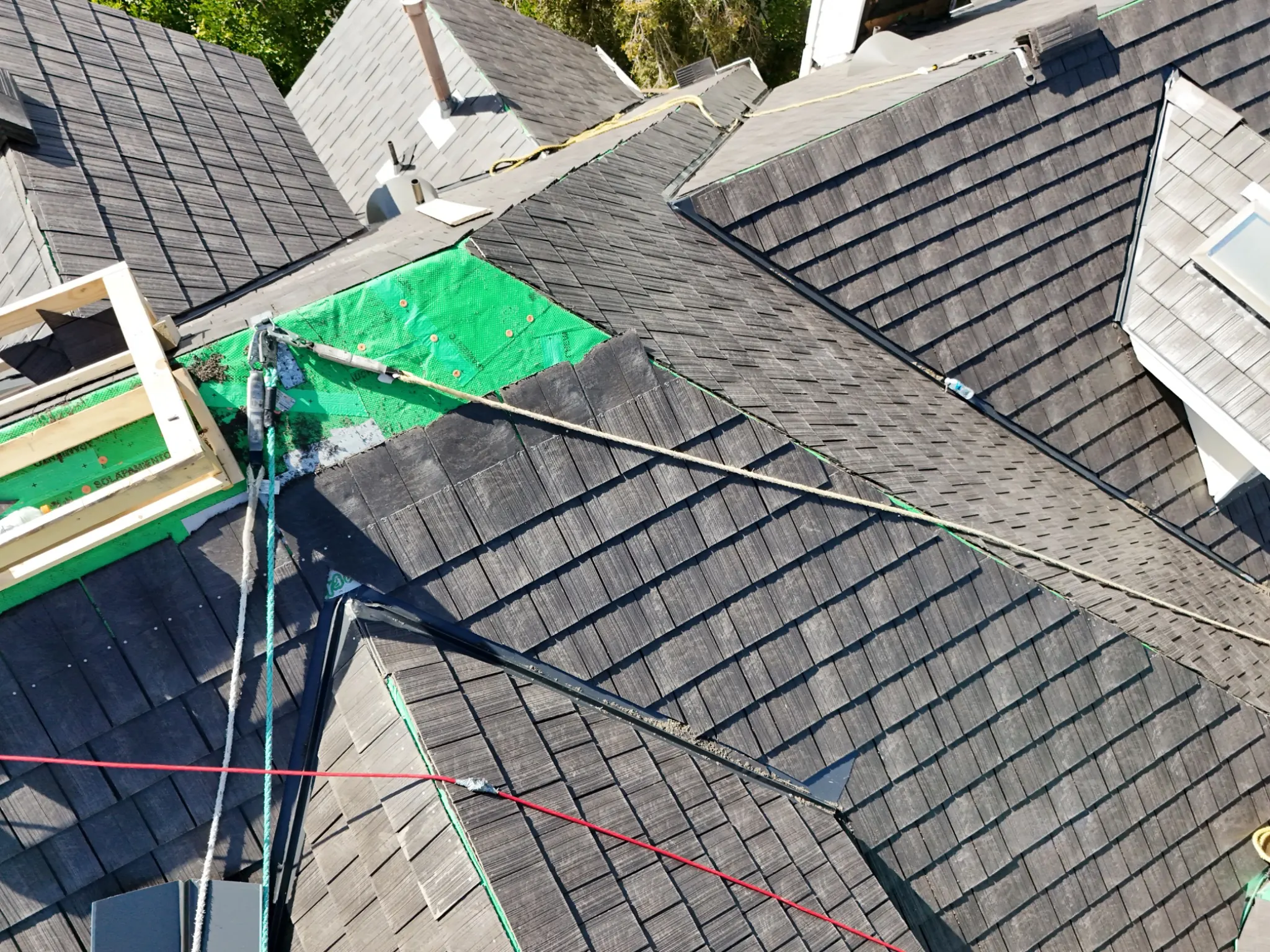 Aged Cedar Enviroshake composite cedar shake roofing during installation on a complex multi-slope roof.