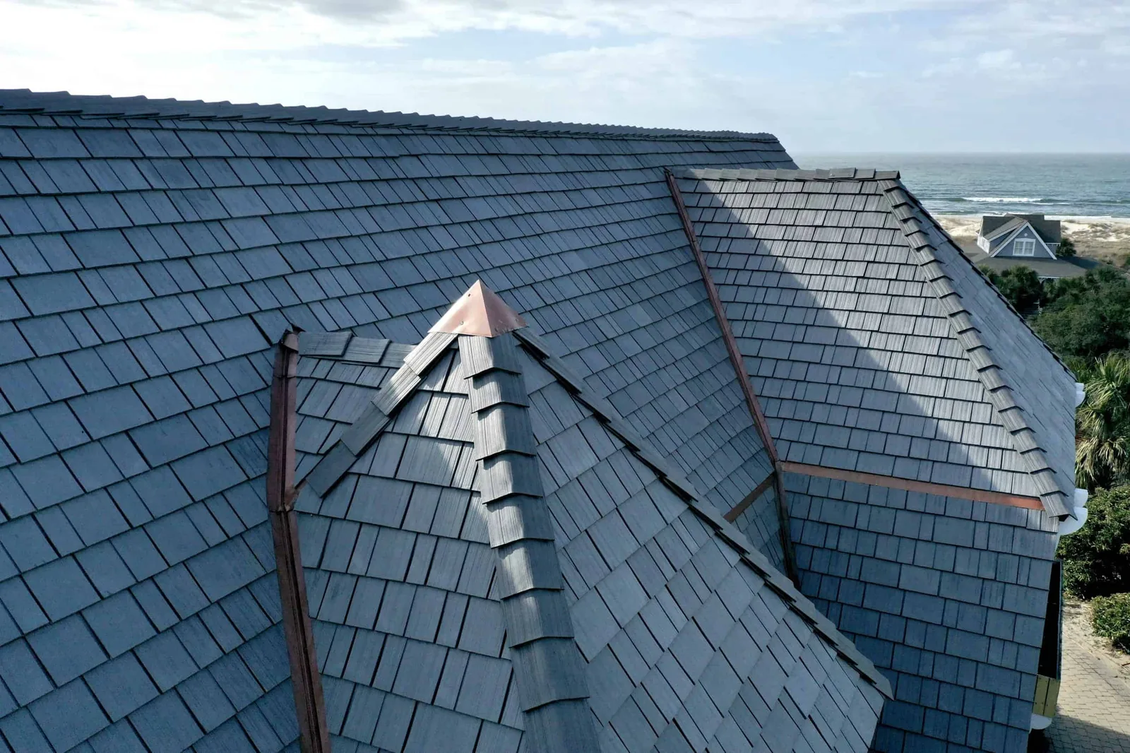 Close-up of Silvered Cedar Enviroshake roofing showing detailed shake texture, ridge caps and copper roof accents.