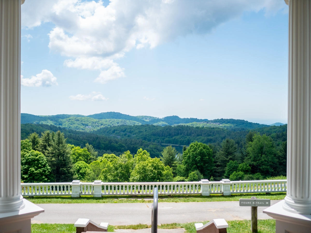 Scenic mountain and forest view from the front entrance of a historic estate.
