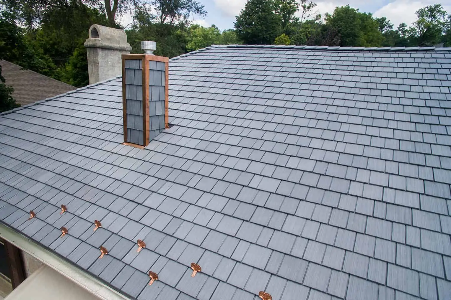 Close-up of an Enviroshake composite cedar shake roof with copper accents and chimney detailing.