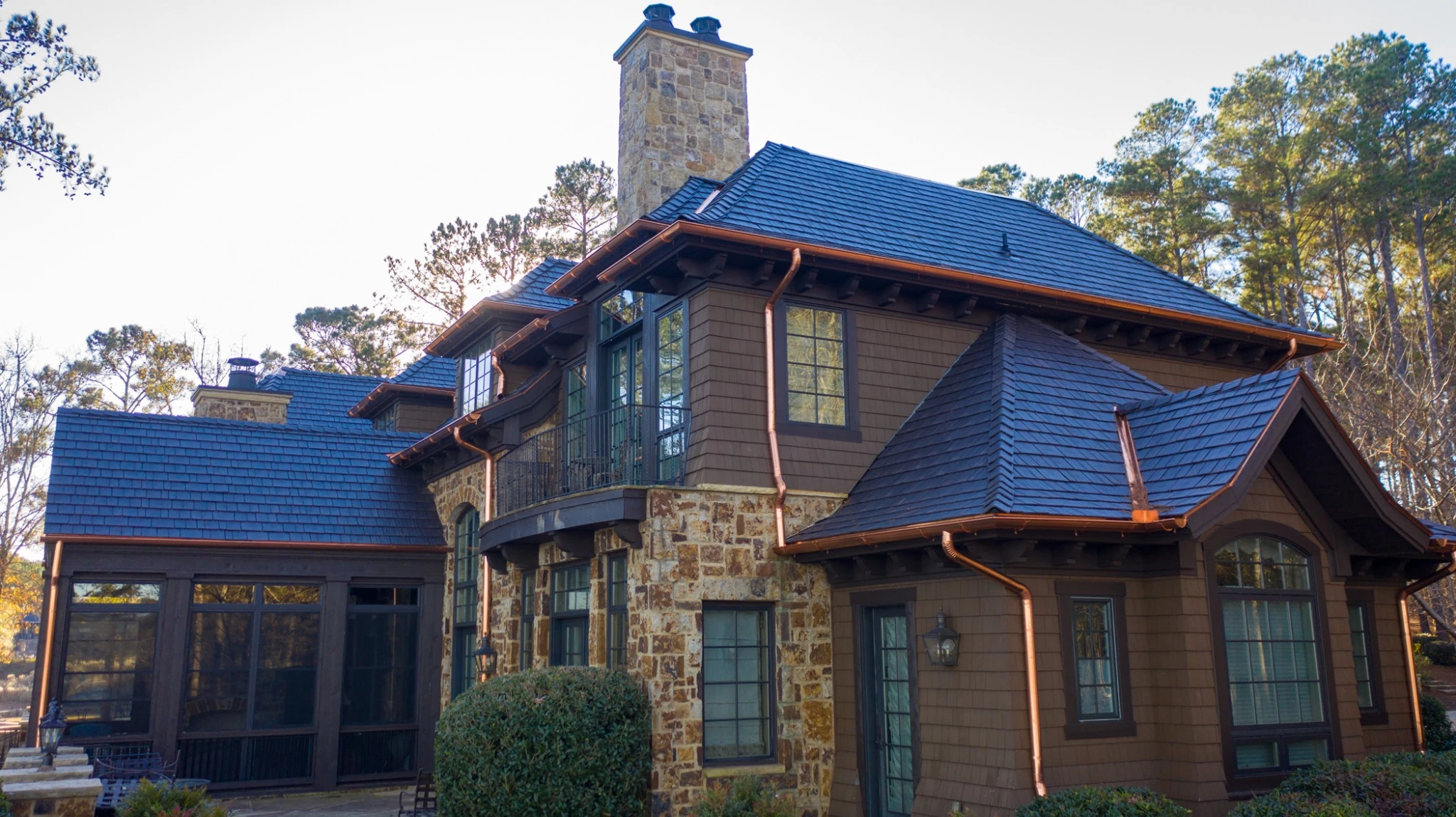 A luxury home in a forest setting with an Enviroshake premium roofing system and copper roof valleys