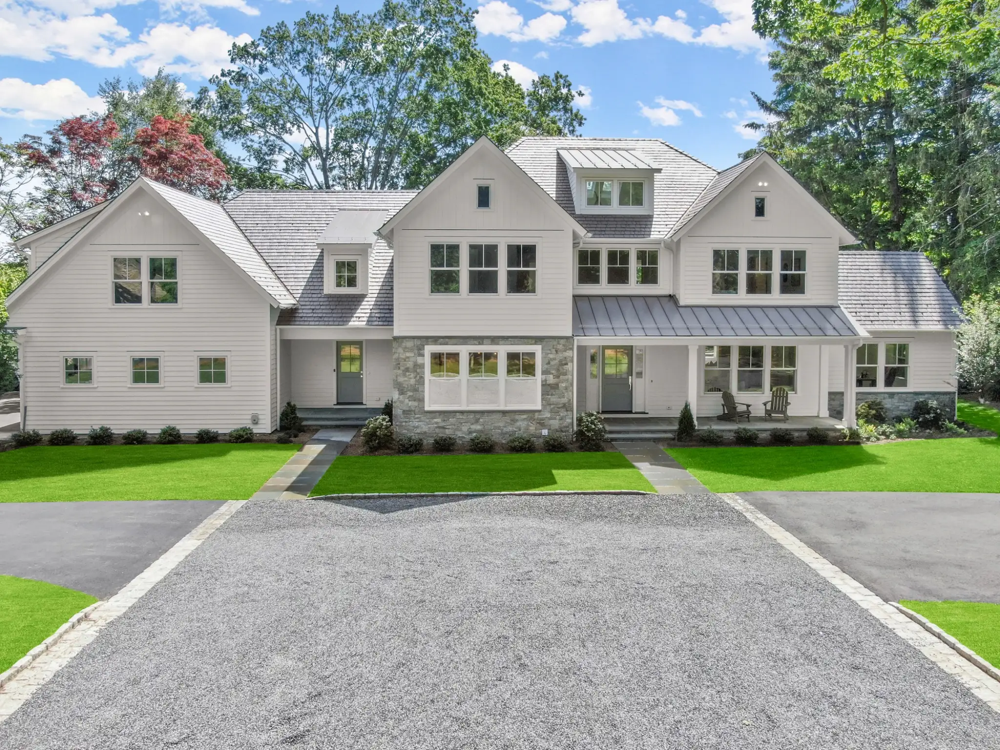 Enviroshake composite cedar shake roofing on a large luxury home with white siding, stone accents and multiple gables.