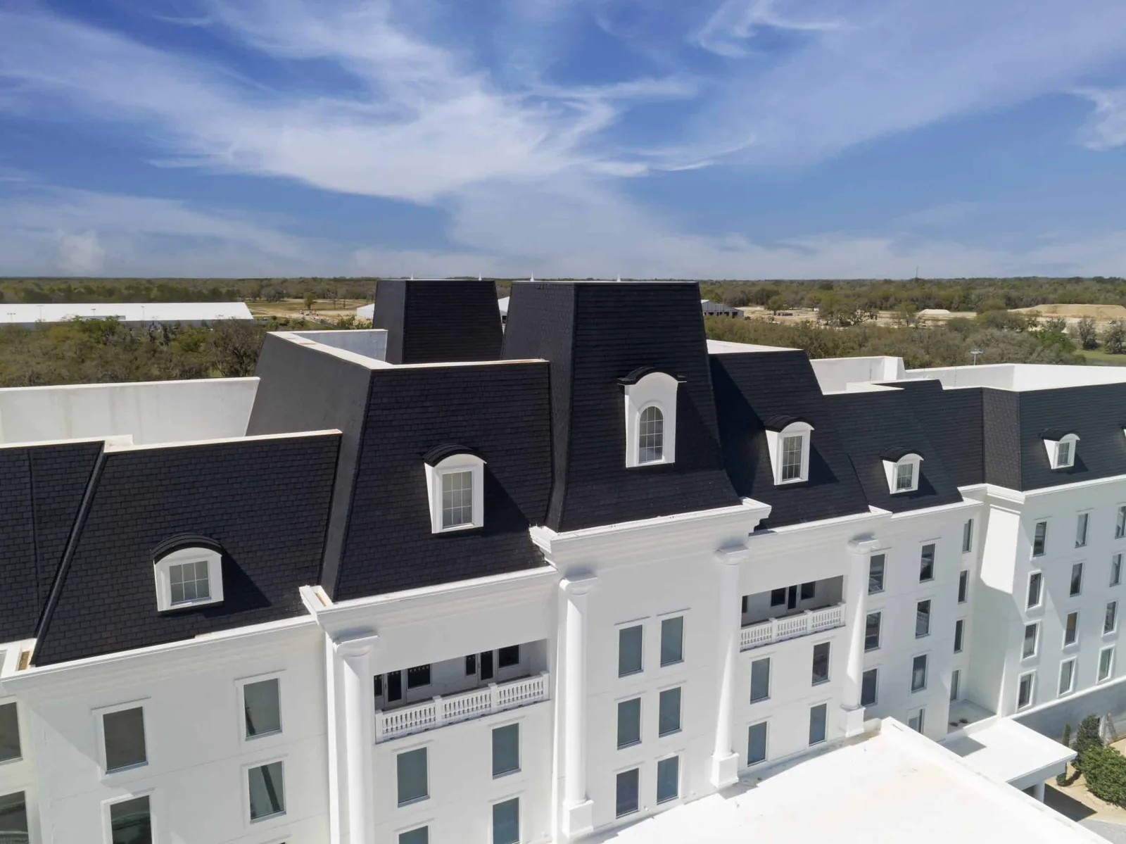 Black Enviroslate composite slate roofing on the World Equestrian Center hotel, featuring steep mansard-style rooflines and dormer windows.